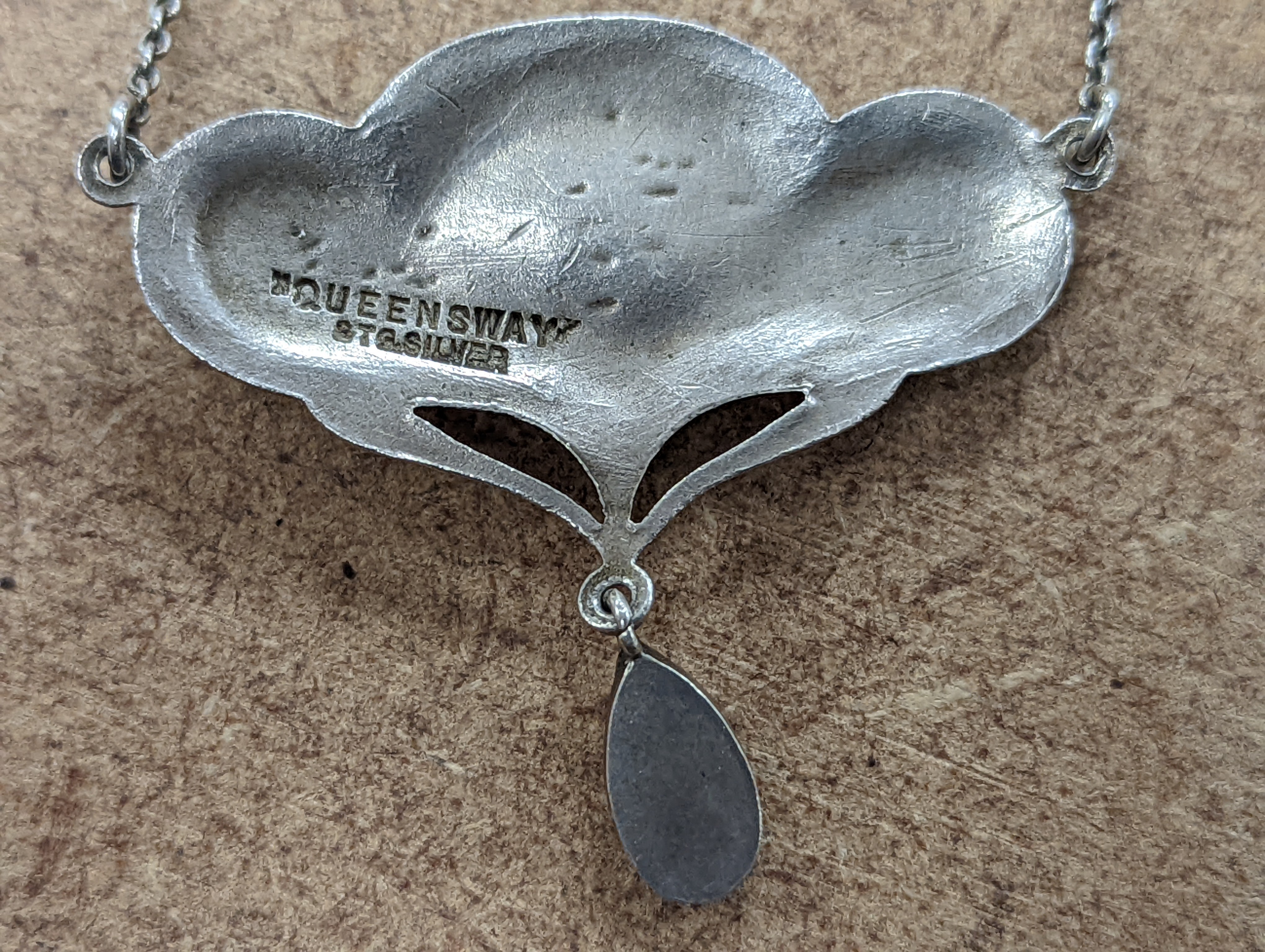 An Art Nouveau style sterling and mother of pearl set pendant necklace, stamped Queensway, 62cm and a white metal bangle.